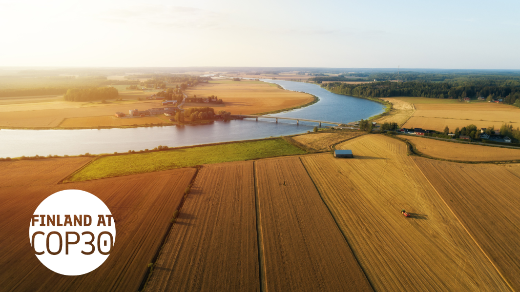 SUomalaista maaseutumaisemaa kuvattuna ilmasto: peltoa, metsää, joki, COP30-logo vasemmassa kulmassa
