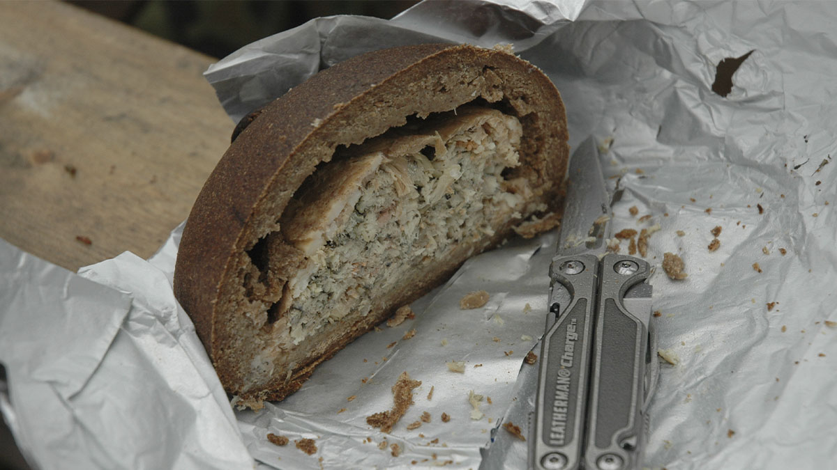 Puolikas kalakukko ja leikkuuveitsi foliopaperilla